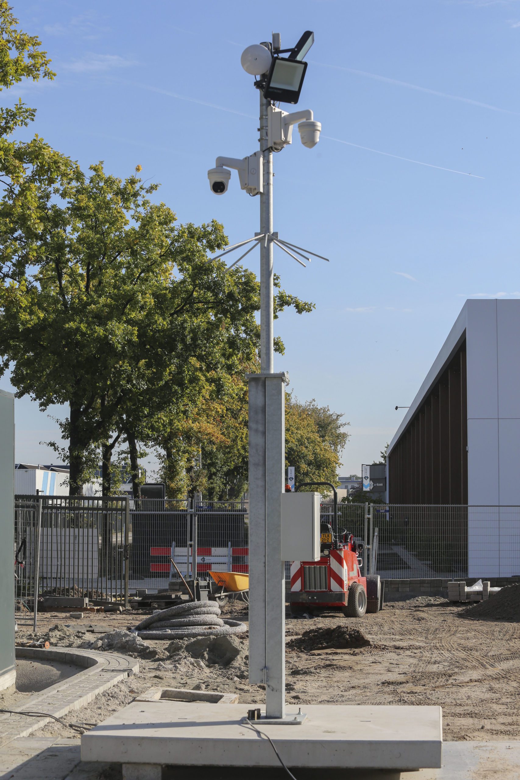 Tijdelijke cameramast met camera’s en schijnwerper op een bouwterrein