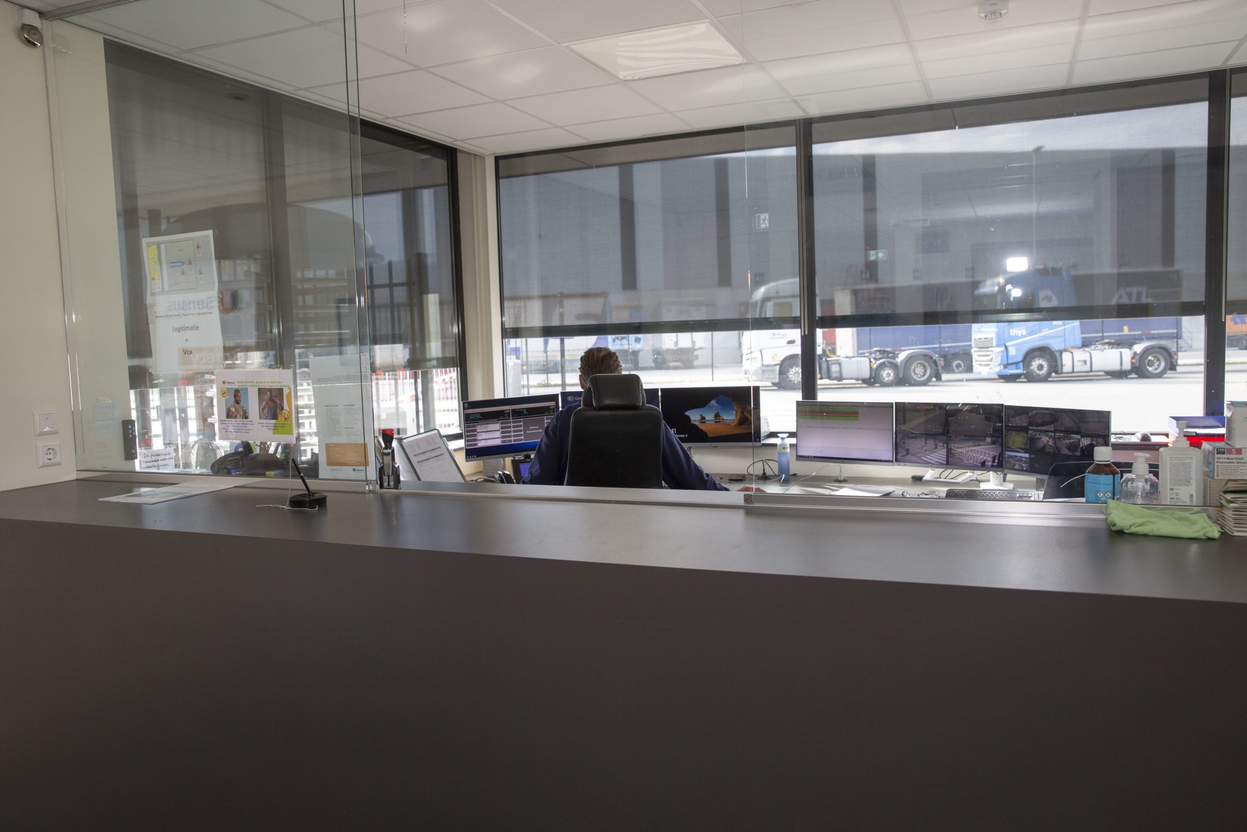 Receptiemedewerker achter de balie in een bedrijfsentree